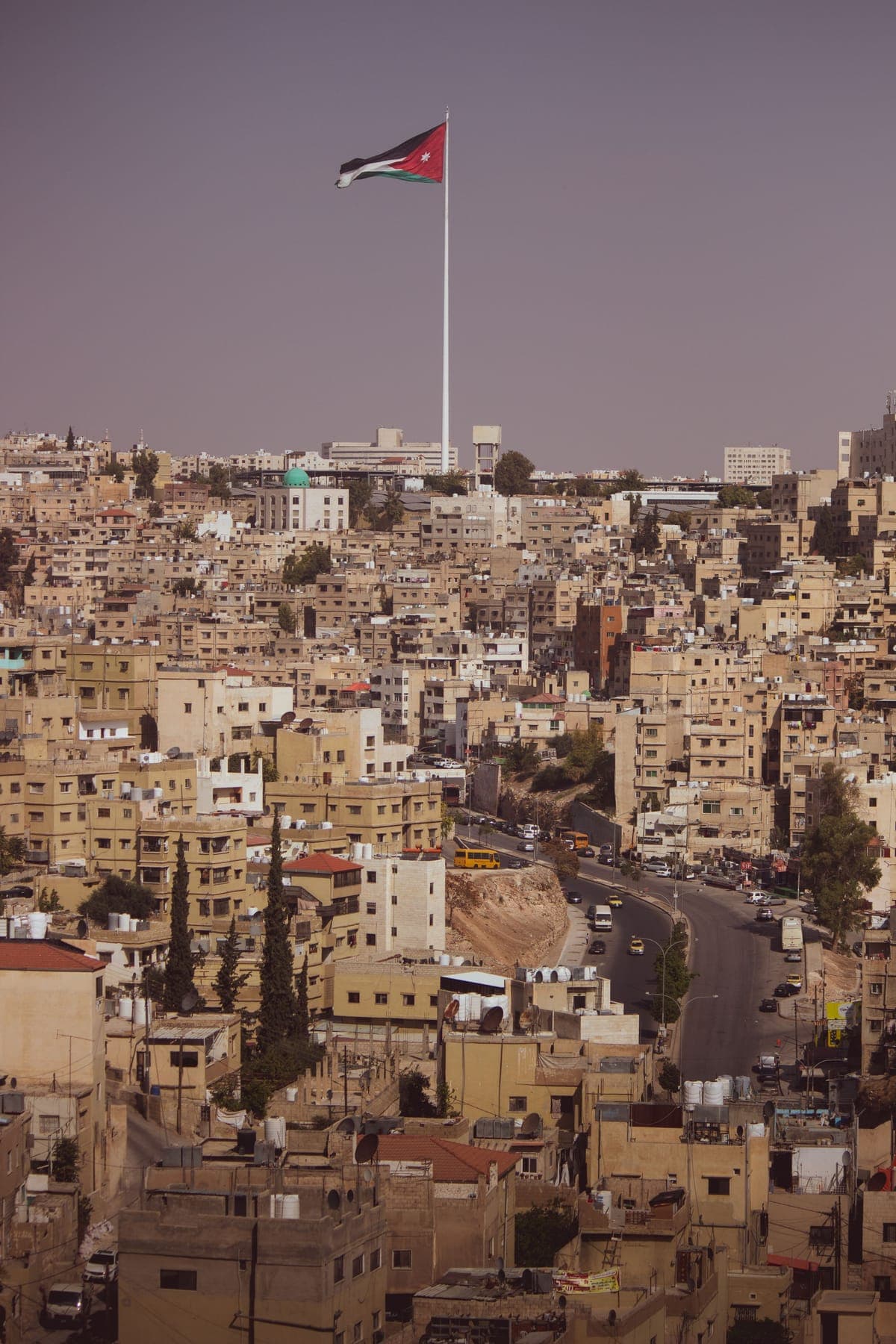 تلال عمّان وبيوتها الحجرية تحت العلم الأردني